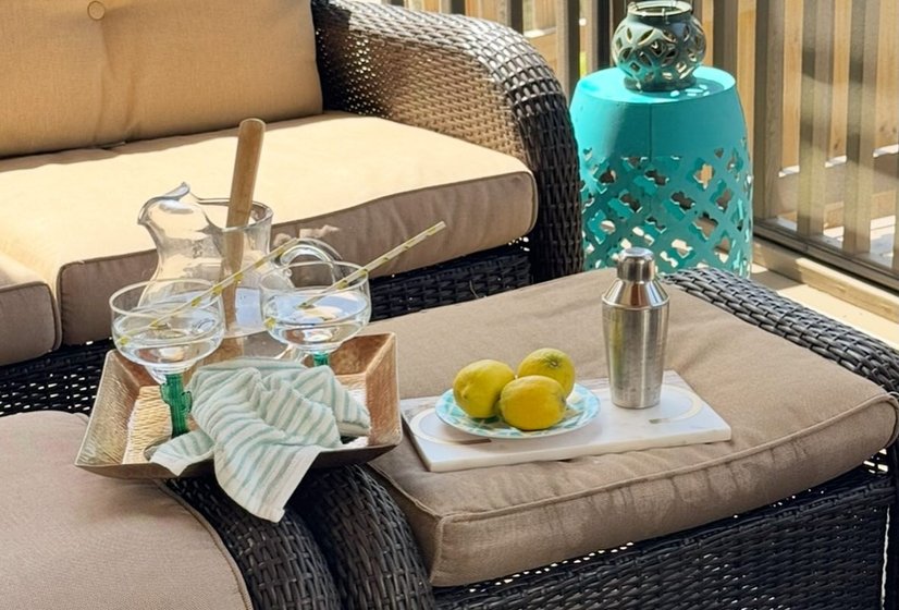 Cozy porch seating with a tray of lemons and glasses on an ottoman